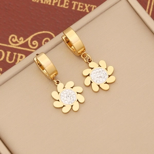 Detailed macro view of gold-plated flower earrings with sparkling pavé crystal centers