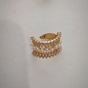 Detail of vintage gold ear cuff featuring synthetic pearls and sparkling zircon stones
