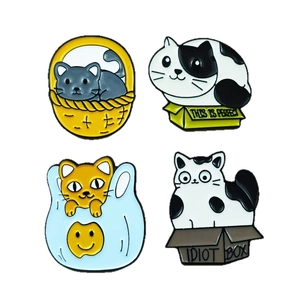 Set of four cute cartoon cat enamel pins in colorful boxes and bags for clothing
