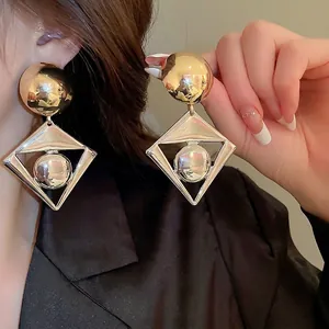Exaggerated geometric color-block earrings with gold disc and silver diamond frame