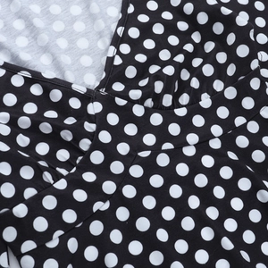 Dettaglio della scollatura a V con drappeggio e classico motivo a pois bianco e nero