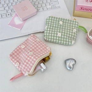 Detailed close-up of embroidered mesh mini cosmetic bags with pearl zipper on desk