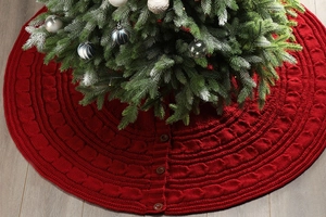 Macro detail of red knitted Christmas tree skirt with cable stitch and vintage buttons
