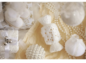 Detail of luxury white Christmas ornaments set with embroidery, pearls and velvet textures