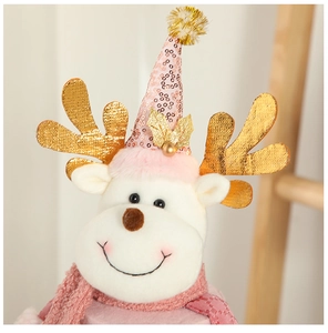 Close-up of pink and gold reindeer doll with sequin hat and knit scarf for Christmas