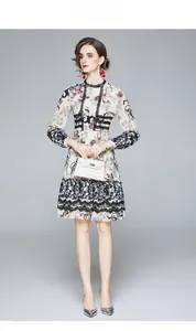 Détails de robe en mousseline fleurie avec inserts en dentelle noire et ourlet à volants
