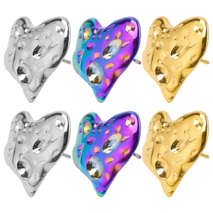 Macro detail of heart-shaped earrings featuring textured hammered metal in three colors