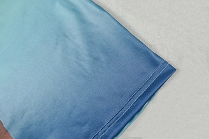 Macro shot of blue and cyan gradient fabric with high-quality double-needle stitching detail