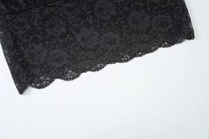 Gros plan sur de la dentelle florale noire aux bords festonnés sur fond blanc