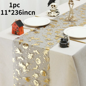 Detail of gold skull and rose pattern on gray tulle Halloween table runner for festive decor