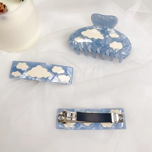 Blue acetate hair claw clip set with white cloud pattern on soft mesh background