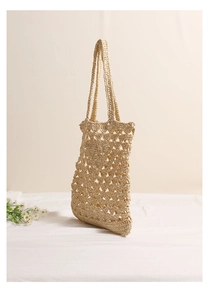 Detail of beige straw woven tote bag featuring hollow mesh pattern for summer beach use