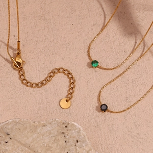 Detail of 18K gold-plated woven chain with green and black zircon pendants and lobster clasp