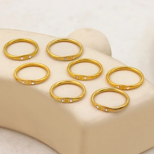 Gold plated stainless steel zodiac rings with sparkling crystals on white pedestals