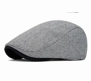 Detailed view of light gray herringbone tweed fabric and stitching on a newsboy cap
