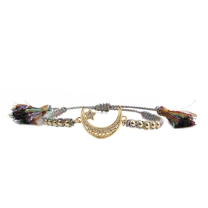 Detail of bohemian woven bracelet with gold moon star charms and colorful tassels
