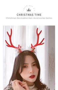 Close-up of reindeer antler headband with white feathers, pine cones and gold bells
