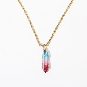 Close-up of a gradient blue and pink hexagonal crystal pendant with gold wire wrapping