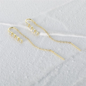 Macro shot of long gold tassel earrings with glittering cubic zirconia stones