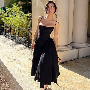 Sleeveless black maxi dress with waist-slimming fit shown in an elegant outdoor setting