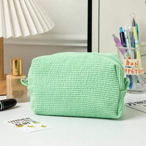Macro detail of seersucker textured light green makeup bag with zipper closure