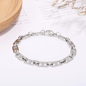 Detailed view of silver coffee bean link bracelet on a minimalist natural background