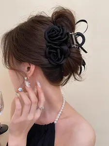 Detailed back view of a large black double rose hair claw clip styled on a woman's hair