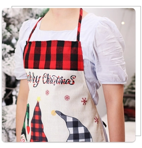 Close-up of a Christmas apron with forest gnome print and red-black checkered pattern