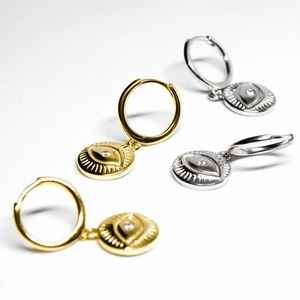 Macro shot of evil eye earrings in gold and silver finish with crystal inlay details