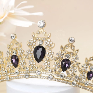 Detailed close-up of a royal crown with purple pear-cut gems and sparkling white crystals