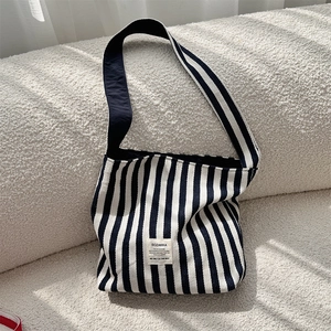 Detailed view of striped canvas tote bag fabric and woven SOZAKKA brand label