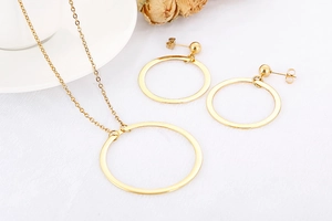 Flat lay of gold geometric hollow circle necklace and earrings set on white background