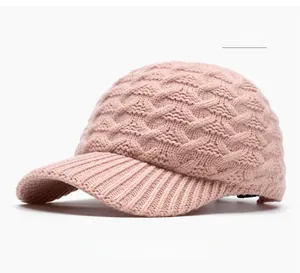 Detail of pink cable knit baseball cap showing thick textured yarn and warm knitted brim