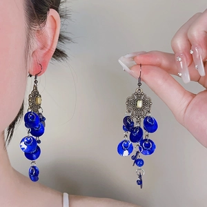 Close-up detail of vintage ethnic earrings with royal blue circular dangling sequins