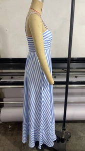 Detail of blue and white striped maxi dress featuring red straps and ruffled hem design