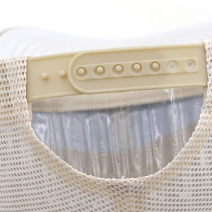 Detail showing breathable mesh fabric and adjustable snapback closure on the beige trucker hat