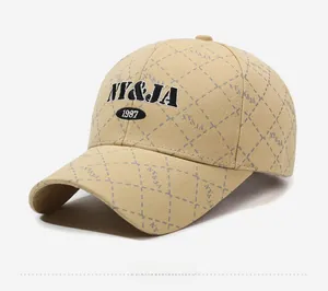 Detail of khaki plaid baseball cap featuring embroidered NY and JA letters in vintage style