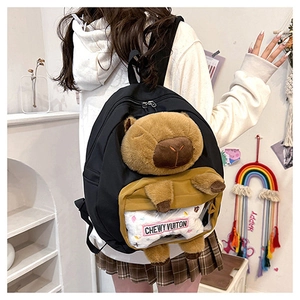 Detail of black canvas backpack with plush Capybara doll and Chewy Vuitton text decoration