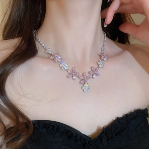 Gros plan d'un collier de fleurs en zircon rose et blanc sur un mannequin pour un look élégant