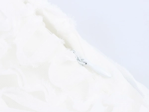 Détail de la fermeture éclair invisible au dos et du tissu en dentelle blanche