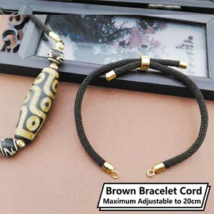 Detailed view of brown braided bracelet cord with gold clasp and 20cm adjustable length
