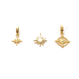 Three gold stainless steel star and compass charms with lobster clasps on white background