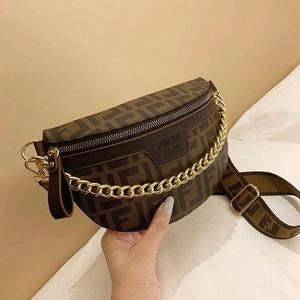 Close-up of brown monogram chest bag with gold chain strap and textured fabric strap