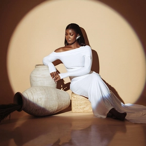 Elegant white one-shoulder long sleeve maxi dress with asymmetrical hem in studio setting