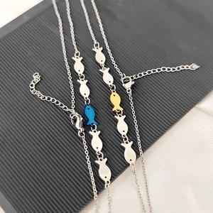 Detail of fish pendant necklaces in silver, gold and blue with lobster clasp and extension