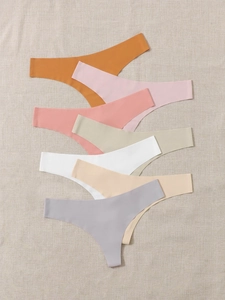 Close-up of seamless stretch sports thongs in a multi-color stack on soft textured fabric