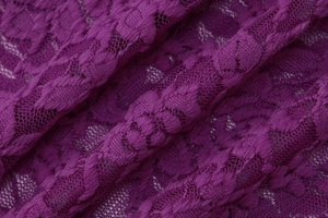 Vue macro montrant le motif floral en dentelle et la texture résille du haut fuchsia