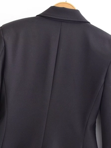 Détail du dos du blazer noir cintré montrant les coutures ajustées et le tissu haut de gamme