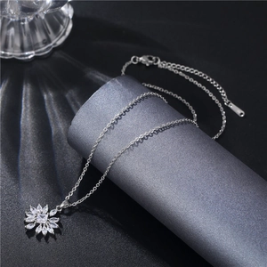 Detailed close-up of a silver flower necklace with marquise zircon stones on a pedestal
