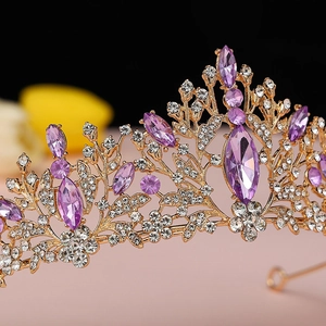 Macro shot of gold tiara detailing purple marquise gems and intricate leaf patterns